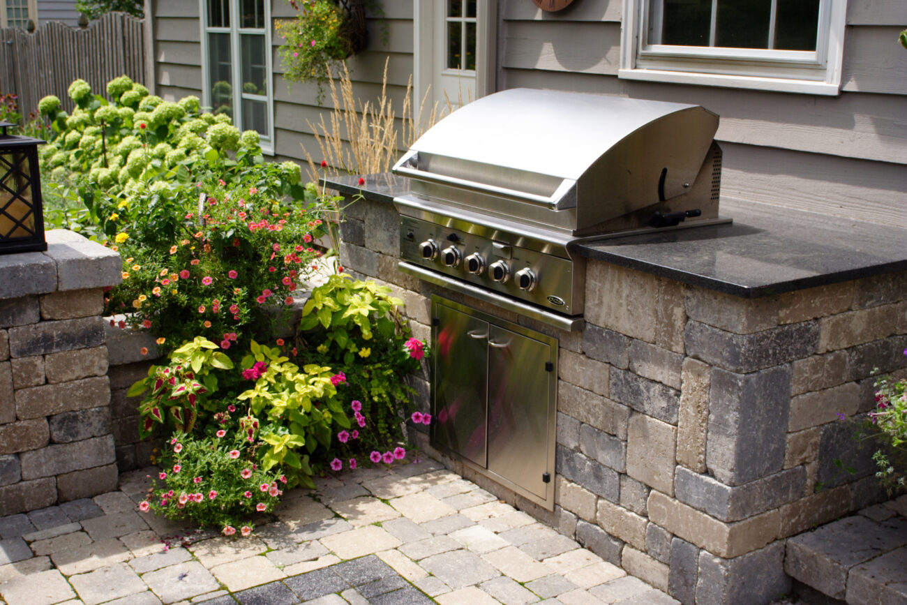 Built-in stainless grill and stone outdoor kitchen island with granite counter in Naperville, IL