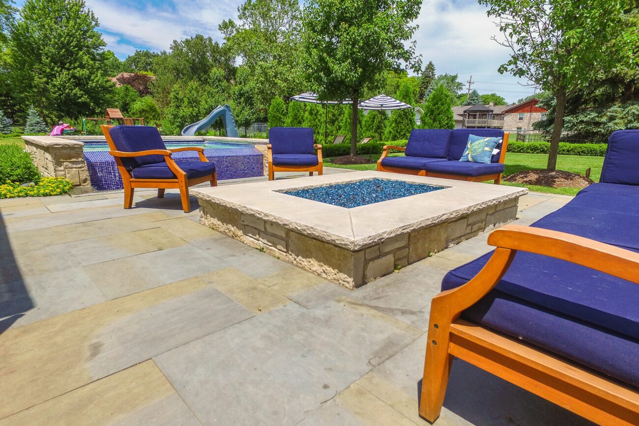 Rectangular gas fire table with glass media on a stone patio in Naperville, IL
