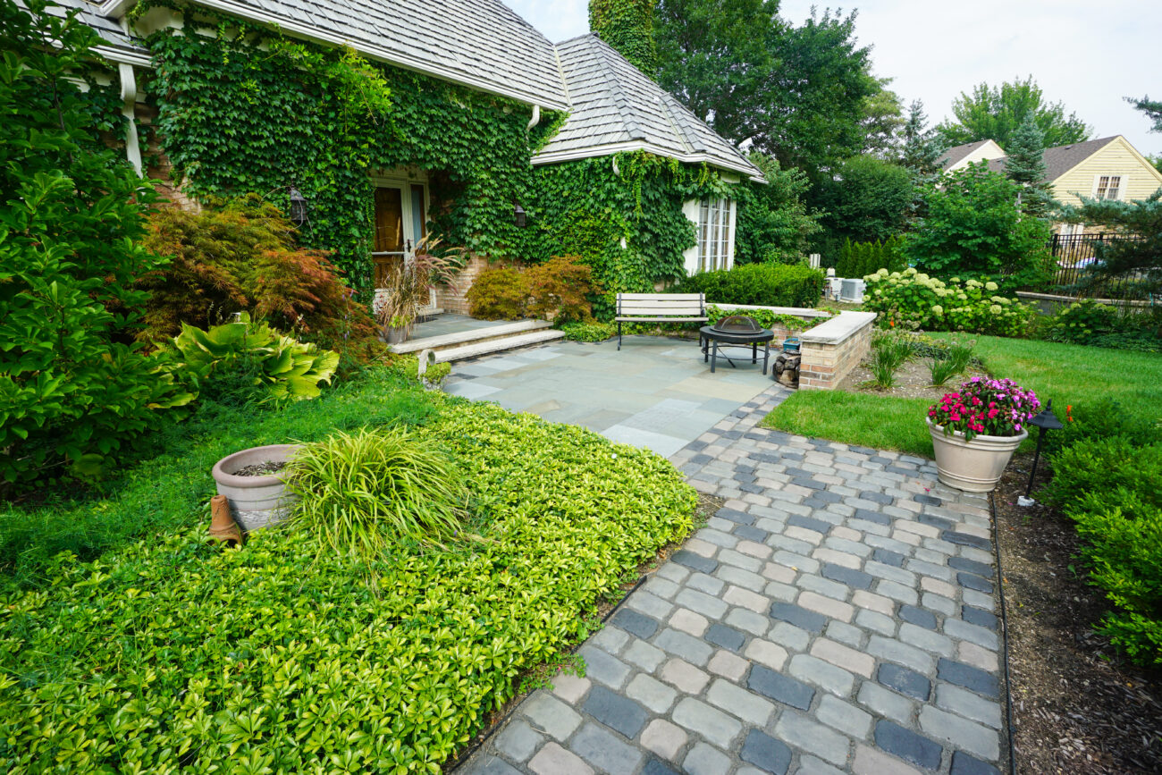 Curved paver walkway and seating area with container plantings in a Naperville, IL yard